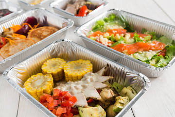 Healthy food take away in boxes, top view at wood