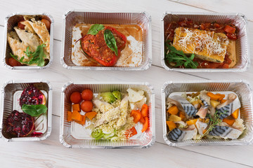 Healthy food take away in boxes, top view on wood