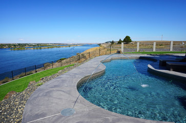 Fototapeta na wymiar modern backyard swimming pool with view of river