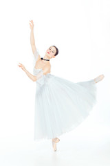 Fototapeta na wymiar Ballerina in white dress posing on pointe shoes, studio background.