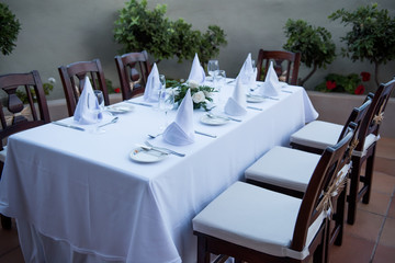 Festively laid table with white tablecloths  glasses and plates