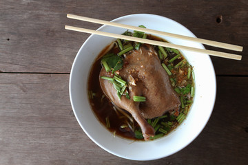 The stewed duck thigh noodles in brown soup  with chopsticks