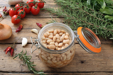 fagioli bianchi bolliti in barattolo di vetro sfondo tavolo di cucina rustico