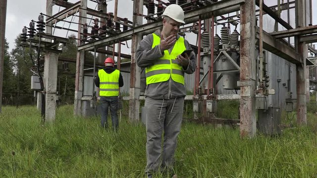 Disappointed electrician using tablet PC in substation