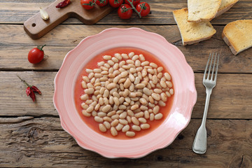 fagioli cucinata in salsa di pomodoro sfondo tavolo di legno rustico