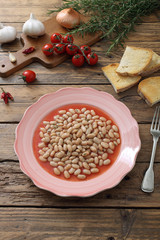 fagioli cucinata in salsa di pomodoro sfondo tavolo di legno rustico