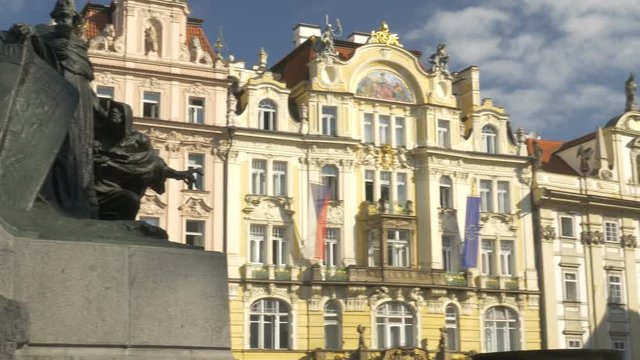 Pan across ornate buildings in old town square Prague from the statue of Jan Husa