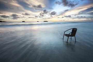 Chair in sea at sunset, long time of shutter speed