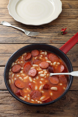 salsicce e fagioli con salsa di pomodoro in padella di metallo sfondo rustico