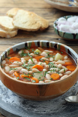 zuppa di fagioli bianchi con verdure su sfondo tavolo di cucina rustico