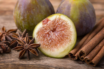 slice of fig with star anise and cinnamon on wood