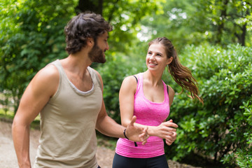 Fototapeta premium Smiling happy couple running in a park