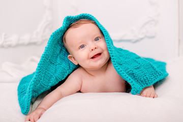 portrait a smile baby under a turquoise blanket