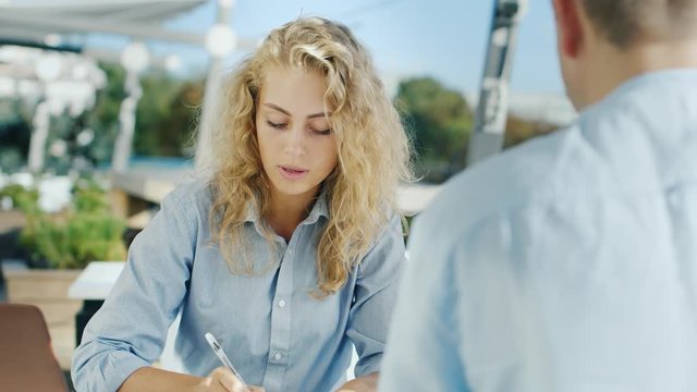 Business woman meets with a client or a partner, a presentation. Second interlocutor seen from the back