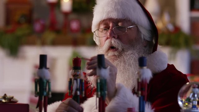 Santa Claus painting toys in workshop
