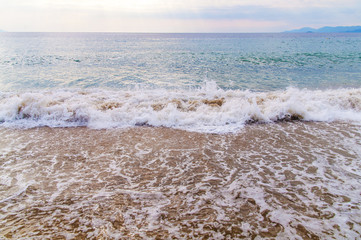 Foam wave on sea with beach background