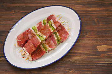 raw meat with pepper for grill on white dish on wooden background