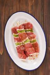 raw meat with pepper for grill on white dish on wooden background