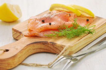 salmon with lemon and black pepper on wooden board