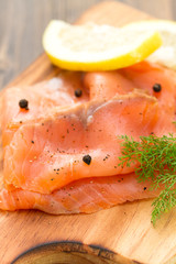 smoked salmon with black pepper on wooden background