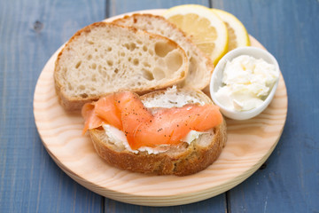 smoked salmon with bread and fresh cheese on wooden board