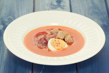 soup on white plate on blue wooden background