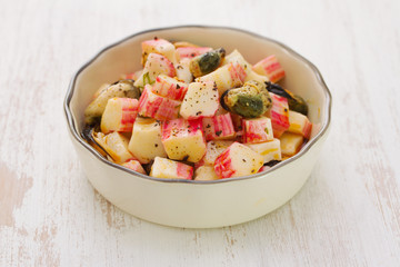 salad with seafood in bowl on wooden background