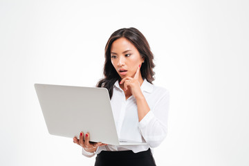 Surprised smart asian businesswoman looking at laptop