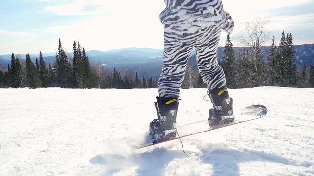 Snowboarder man in suit of kigurumi of zebra jumping and going in high mountains in slowmotion during snowfall. 1920x1080