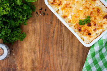 Gratin potatoes on a wooden table, top view