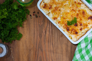 Gratin potatoes on a wooden table, top view