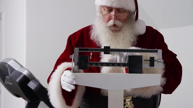 Santa Claus looks at weight on scale