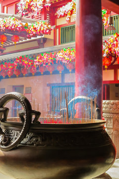 Chinese Incense stick in a pot. Interior of the Buddhist temple