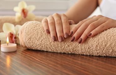 Female brown manicure on towel, closeup