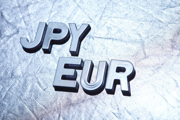 letters on silver background spelling JPY/EUR