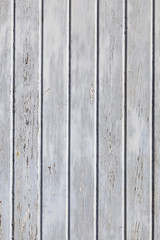 vertical part of wooden fence or wall with old bladdered gray pa