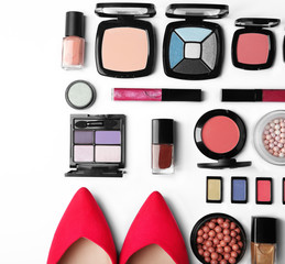 Makeup products, brushes and female shoes on white background
