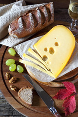 Maasdam cheese, bread, grapes and wineglass
