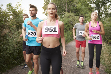 Team of jogging people in the forest.