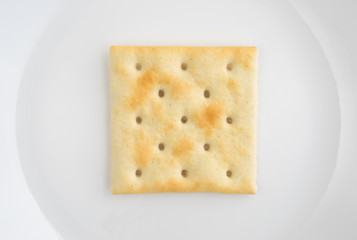 Close view of saltine cracker on a plate.