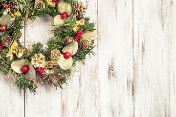 Christmas wreath hanging on wooden door, white background