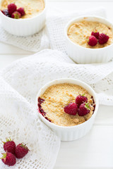 Homemade raspberry crumble on white wooden background
