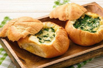 Buns baked with spinach, cheese and egg.