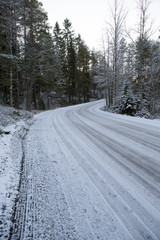 Slippery winter road on a cloudy winter day. Image taken after first snow has arrived in Finland.