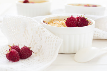 Homemade raspberry crumble on white wooden background