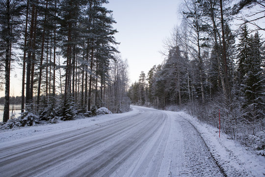 Slippery winter road on a cloudy winter day. Image taken after first snow has arrived in Finland.