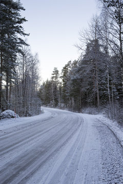 Slippery winter road on a cloudy winter day. Image taken after first snow has arrived in Finland.