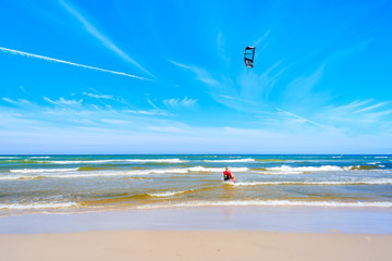 A man kite boarding on Baltic Sea at Debki beach, Poland