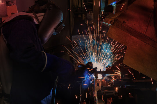 worker is welding  part in automotive industrial factory