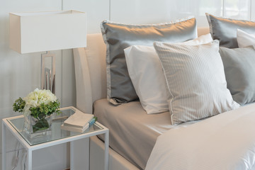 pillows set on bed with vase of flower in luxury bedroom